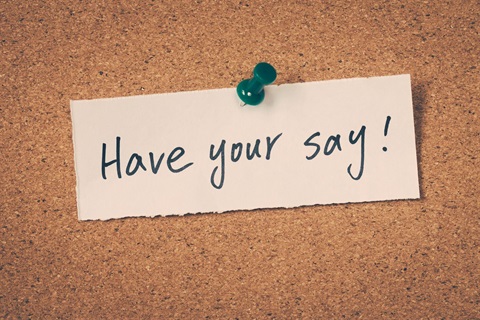 Photo of a cork board with a strip of paper tacked to it that says have your say