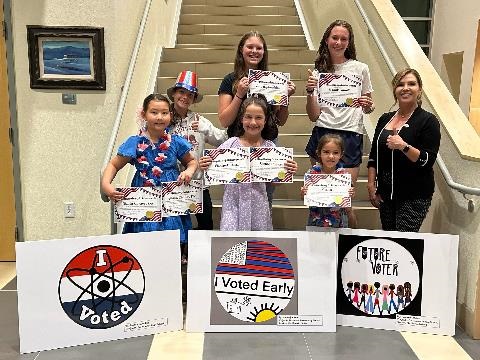 Photo of County Clerk Naomi Maestas and the Children who won the I voted, I voted early, and future voter sticker contest.   