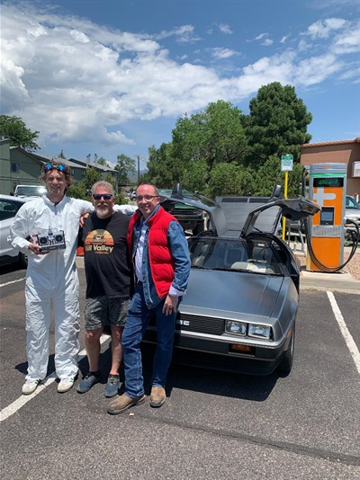 Doc Brown, Jon McLellan, and Marty in front of a DeLorean and the DC Fast Charger
